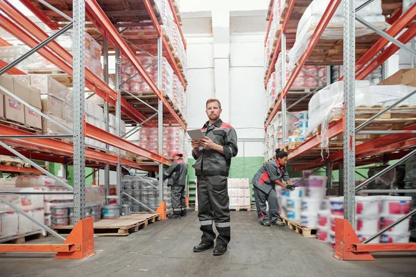 Grave Giovane Lavoratore Maschio Magazzino Uniforme Utilizzando Tablet Mentre Piedi — Foto Stock