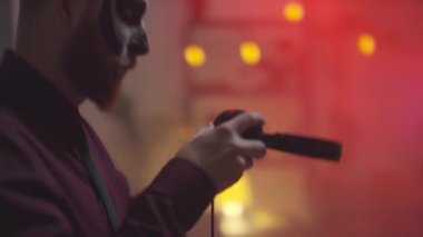 Cadılar Bayramı makyajı yapan sakallı bir adamın partide müzik eşliğinde kulaklık takıp dans ettiği el kamerasıyla çekildi.