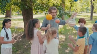 Sakallı bir fen bilgisi hocasının ve gezegenlerin modellerini taşıyan bir grup meraklı çocuğun çekimleri ve yaz günü parkta güneş sistemi hakkında bir şeyler öğrenmek.
