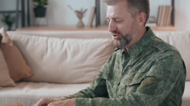 Üniformalı mutlu sakallı erkek subayın ve oğlunun oturma odasında oyuncak askerlerle oynamalarının yavaş yavaş takibi.