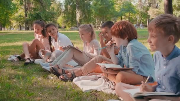 Slowmo Media Toma Niños Felices Con Cuadernos Sentados Mantas Parque — Vídeo de stock