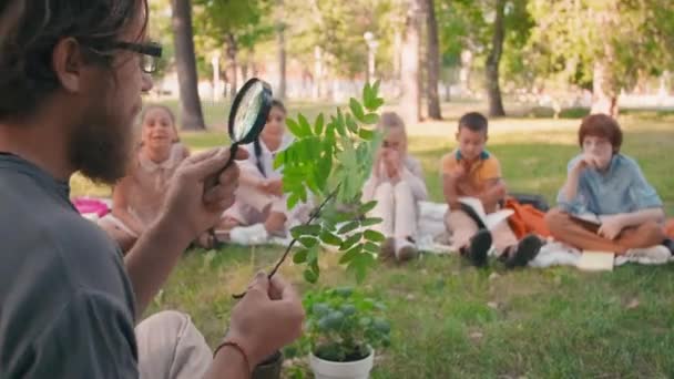 Średnie Ujęcie Brodatego Nauczyciela Okularach Trzymającego Gałązkę Drzewną Szkło Powiększające — Wideo stockowe