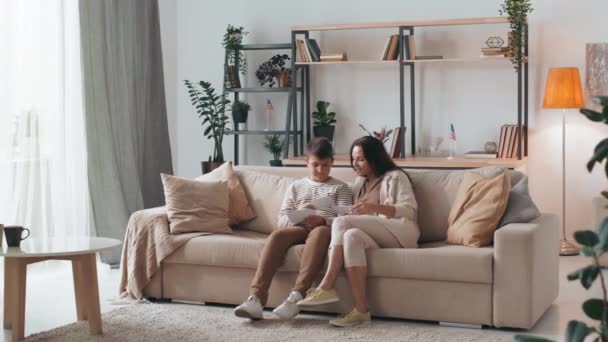 Kamerafahrt Von Frau Und Junge Auf Couch Gemütlichen Wohnzimmer Sitzend — Stockvideo