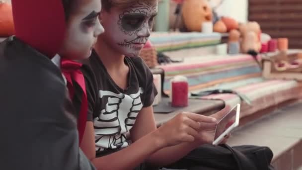 Handheld Tracking Boys Wearing Scary Makeup Costumes Sitting Steps Front — Stock Video