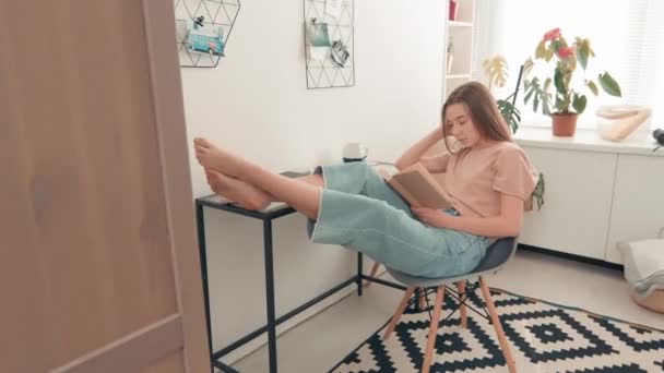 Tracking Shot Young Woman Sitting Chair Her Legs Desk Reading — Stock Video