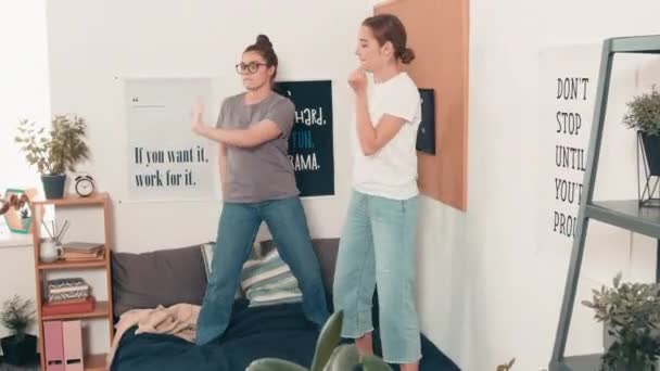 Tracking Shot Felices Amigas Jóvenes Sonriendo Bailando Cama Juntas Acogedor — Vídeo de stock