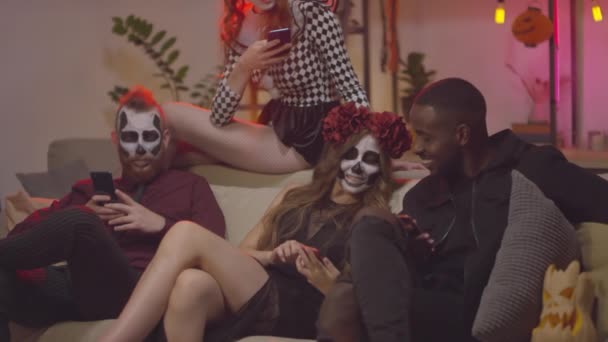 Slowmo Inclinar Mulheres Jovens Felizes Homens Trajes Halloween Sentado Sofá — Vídeo de Stock