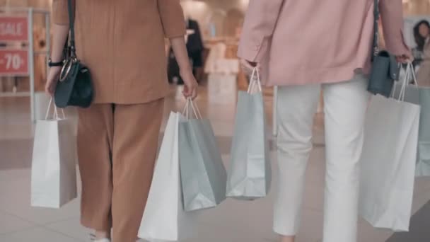 对携带购物袋走进精品店的无法辨认的年轻妇女进行慢速跟踪 — 图库视频影像