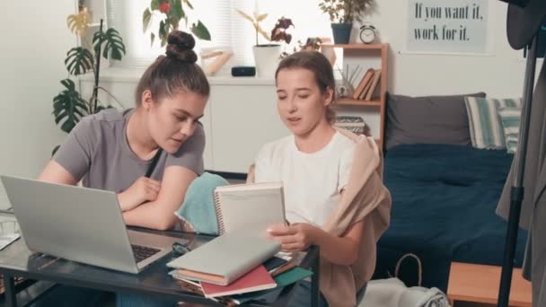 在舒适的卧室里 追踪坐在课桌前 一起执行任务的快乐年轻女大学生的照片 — 图库视频影像