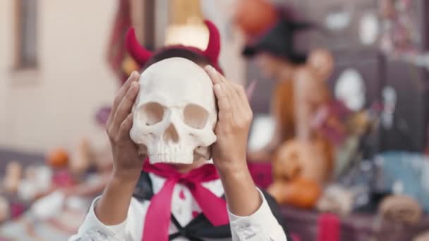Retrato Niño Lindo Disfrazado Halloween Sosteniendo Cráneo Falso Ante Cara — Vídeo de stock
