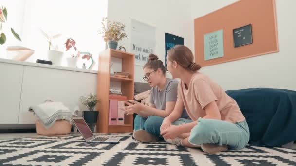 在舒适的卧室或宿舍里 快乐的年轻女性坐在地板上 与一群人通过笔记本电脑进行视频交谈的手持跟踪照片 — 图库视频影像