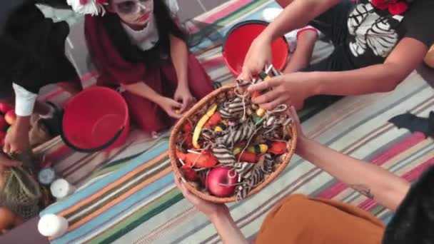 手持式头像照片 孩子们穿着哈洛服装 从女人手里接过篮子里的糖果 — 图库视频影像