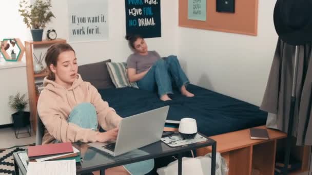 Female College Student Typing on Laptop and Chatting with Roommate — Stock Video