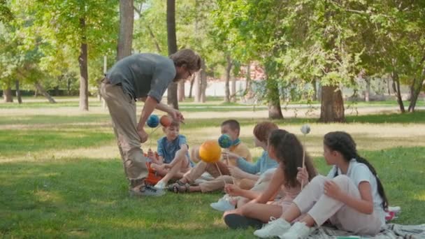Orta Boy Gözlüklü Erkek Fen Öğretmeni Parktaki Yeşil Çimenlerin Üzerinde — Stok video