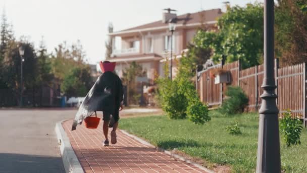 Slowmo Tiro Menino Traje Halloween Com Capa Carregando Cesta Andando — Vídeo de Stock