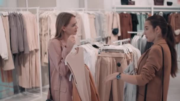 Medium Shot Cheerful Female Friends Talking Choosing Clothes Store While — Stock Video