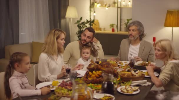 Többgenerációs Családtagok Ülnek Együtt Asztalnál Beszélgetnek Valamiről Miközben Ünneplik Hálaadási — Stock videók