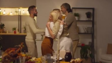 Neşeli genç adam ve kadın aileleri selamlıyor ve onları Şükran Günü yemeğine davet ediyor.