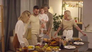 Büyük nesil aile Şükran Günü kutlaması için yemek masasında toplanıyor.