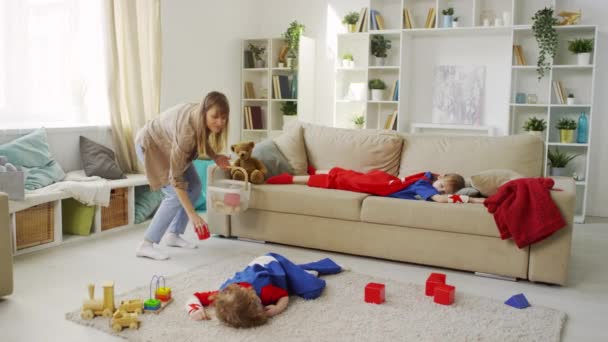 Úplný Záběr Mladé Matky Sbírat Rozptýlené Barevné Hračky Podlahy Košíku — Stock video