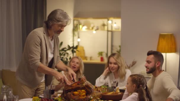 Vrolijke Volwassen Man Staat Aan Tafel Snijden Geroosterde Kalkoen Het — Stockvideo