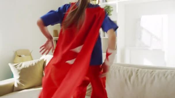 Медленно Следовать Средний Снимок Маленькой Девочки Костюме Супергероя Прыгать Диване — стоковое видео