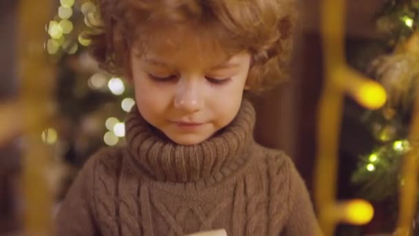 Närbild Söt Liten Pojke Som Håller Julklapp Insvept Hantverk Papper — Stockvideo