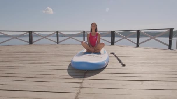 Genç Güzel Bir Kadının Göl Rıhtımındaki Sörf Tahtasına Uzanmış Gözleri — Stok video