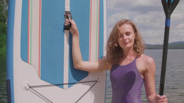 Medium Nærhet Pen Sportslig Kvinne Med Surfeutstyr Som Smiler Foran – stockvideo