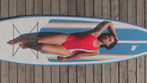 Tahta Göl Rıhtımındaki Kürek Tahtasında Uzanmış Kırmızı Mayo Giymiş Güzel — Stok video