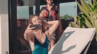 Bronz tenli, güzel bir çiftin telefon görüşmesinde görüntülü sohbet ederken ve dışarıda birlikte otururken gülümsediği orta ölçekli bir yakın çekim.