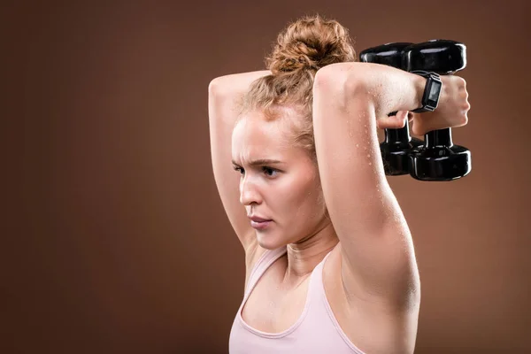Young sweaty sportswoman in activewear making effort while doing difficult  exercise for arm muscles with dumbbells in isolation — Real People, beauty  - Stock Photo | #392127320