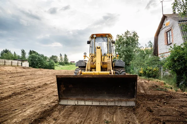 büyük sarı Lastik tekerlekli yükleyici toprak yeni bir bina için hizalar
