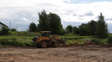 büyük sarı Lastik tekerlekli yükleyici toprak yeni bir bina için hizalar
