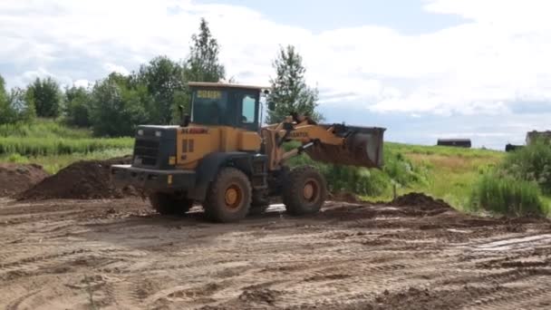 大きな黄色いホイール ローダー整列の新しい建物のための土地 — ストック動画
