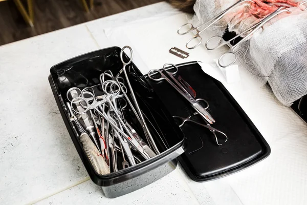 Instrumentos médicos estériles de un médico cirujano doblados en una caja negra. Conjunto de un veterinario para la esterilización y otras operaciones con animales . — Foto de Stock