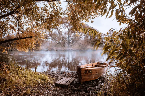 Nehirde sabah sisi ve gizemli bir nehrin kıyısında unutulmuş bir tekne. — Stok fotoğraf