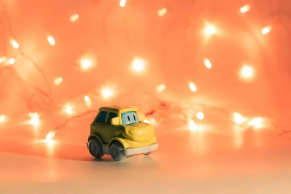 Green toy car on a orange background with bright lights and place for text — Stock Photo, Image