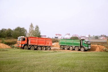 İki büyük 70 tonluk damperli kamyon inşaat alanına kum getirdi.