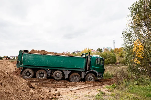 Un gran camión volquete de 70 toneladas trajo arena a un nuevo sitio de construcción para agregar tierra — Foto de Stock