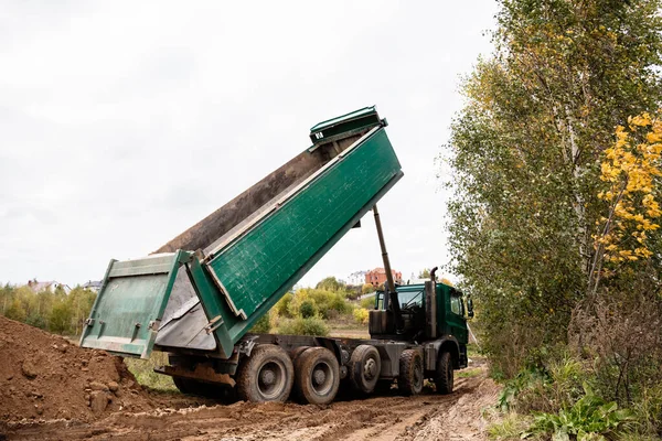Un gran camión volquete de 70 toneladas trajo arena a un nuevo sitio de construcción para agregar tierra — Foto de Stock