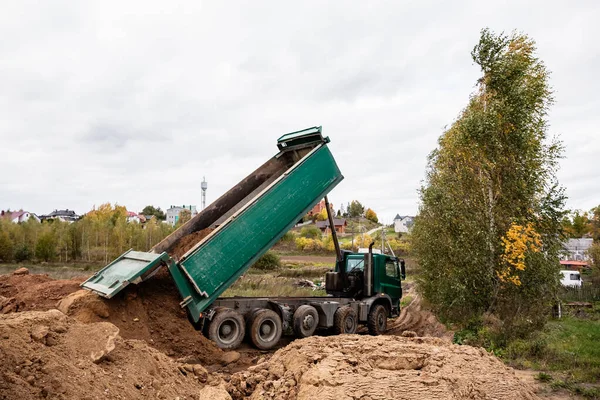 Un gran camión volquete de 70 toneladas trajo arena a un nuevo sitio de construcción para agregar tierra — Foto de Stock