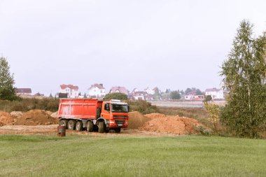 A large 70-ton dump truck brought sand to a new construction site to add land