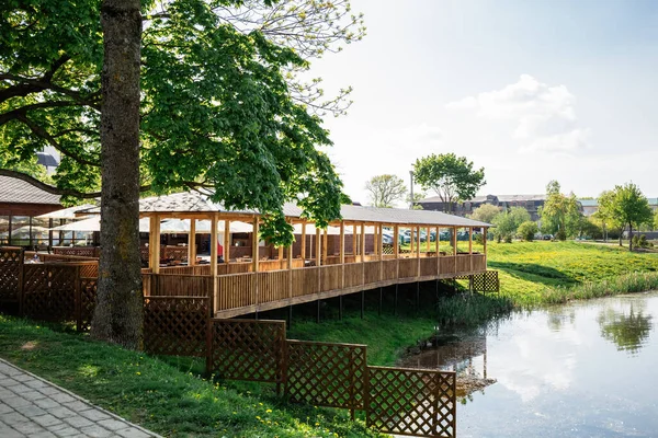 View of the wooden terrace or canopy on the river bank, where the cafe or restaurant. Tourists can relax and eat on the summer terrace with stunning views of the lake. The landscape and the exterior.