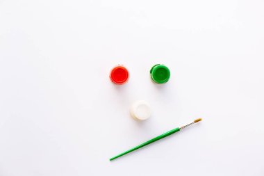 Resim yapmak için üç farklı renk beyaz, kırmızı, yeşil ve fırça yüz şeklinde. Yeni yıl paletini boyamak ya da dekore etmek için aletler. Akrilik ya da gagalı kavanozlar. Üst görünüm duvar kağıdı