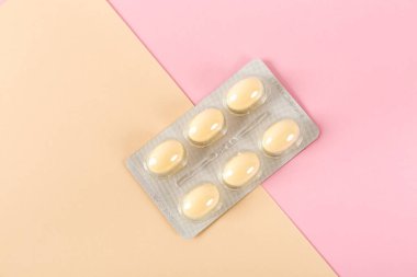 Pembe arka plandaki tabletler, vajinal antibakteriyel kapsüller yakın plan.