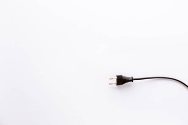 Beyaz arka planda hiçbir şey olmadan izole edilmiş kabloyla siyah düz elektrik prizi. Cihaz kapalı. Elektrik güvenlik önlemleri var. Yakın plan..