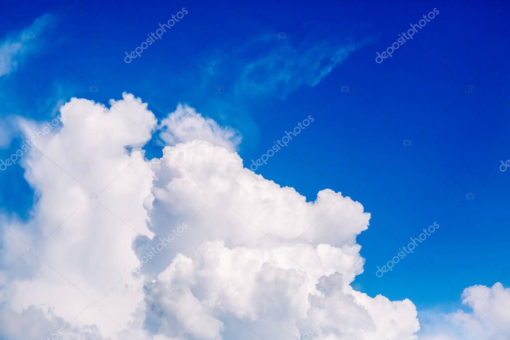 Large white air cloud in the blue sky. The weather forecast reports on partly cloudy weather and a change from cyclone to anticyclone. Environmentally friendly source of energy. Wallpaper banner.