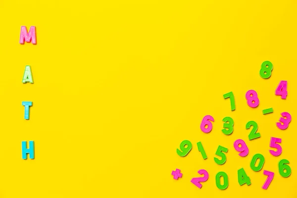 수학이라는 단어는 노란색 배경에 플라스틱 장난감 글자로 쓰여져 근처에는 9까지의 — 스톡 사진