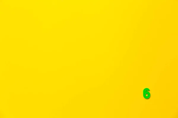 Зеленая Пластиковая Игрушка Номер Шесть Расположена Правом Нижнем Углу Желтом — стоковое фото